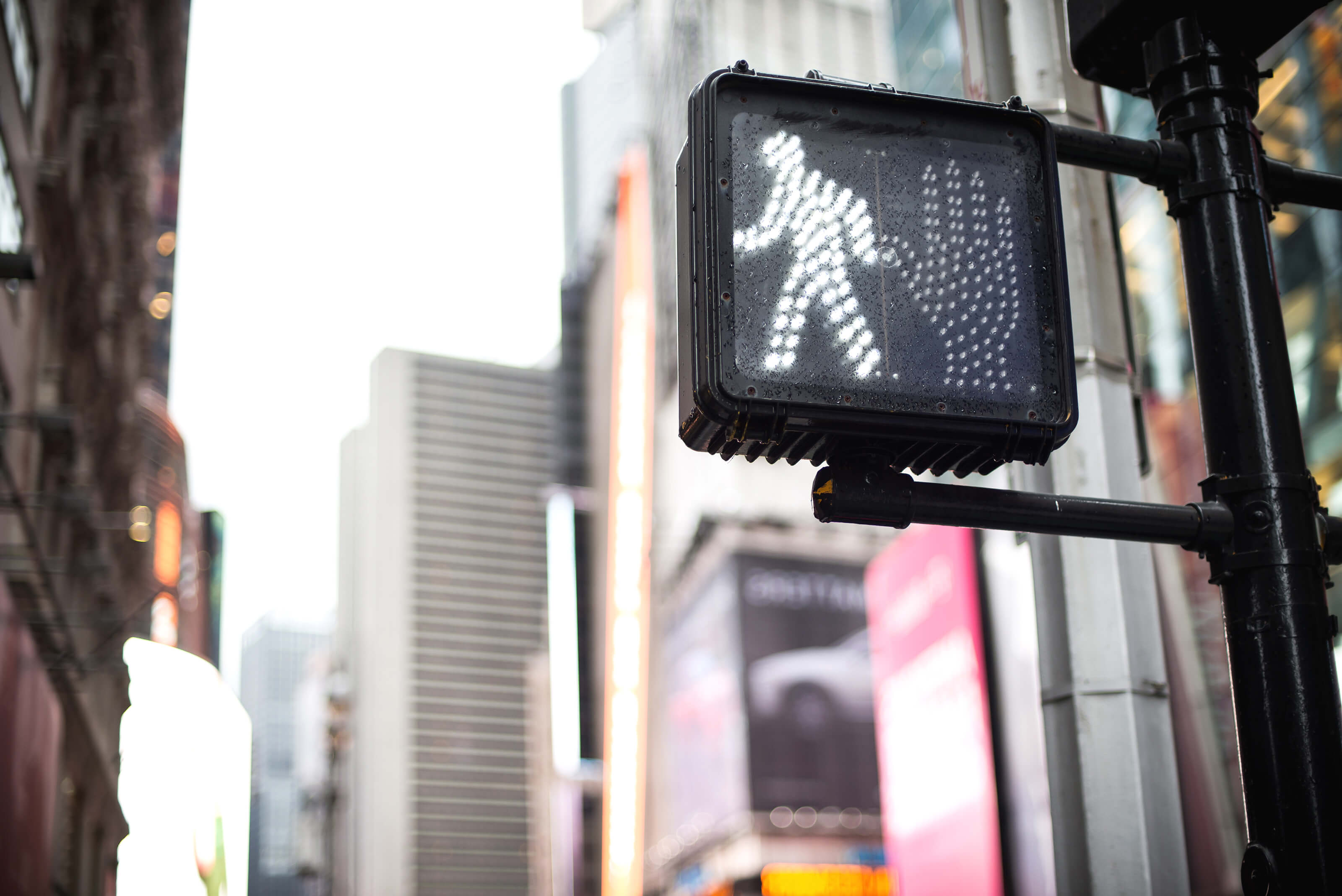 crosswalk sign with "walk" symbol illuminated
